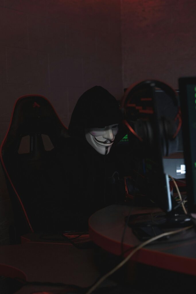 pexels photo 5380606 5380606 A hacker in a Guy Fawkes mask working on cybersecurity at night, conveying secrecy.